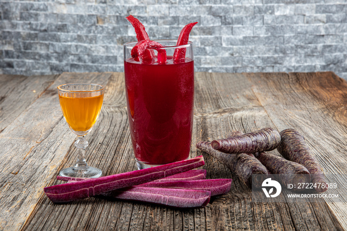 Traditional turkish drink turnip juice (Salgam). Drink Salgam, red carrot and turnip juice on a wooden background.