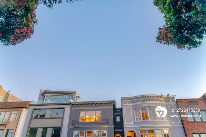 Facade of modern and victorian townhouses in a low angle view at San Francisco, CA