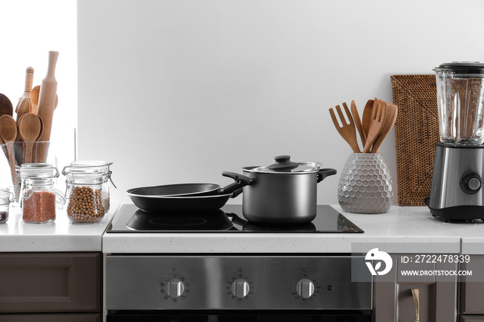 Modern electric stove and utensils in kitchen