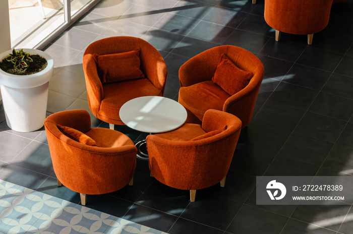 Orange chairs and table in a hotel lobby