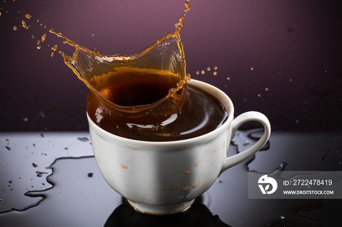 Coffee splash in white mug with reflection on gradient background