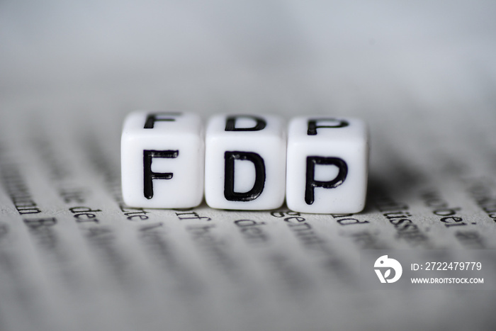 Word FDP formed by wood alphabet blocks on newspaper german party politics