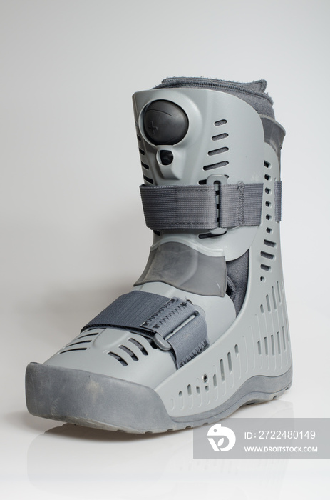 A orthopaedic grey plastic boot ankle brace injury protecting boot, with velcro straps isolated on a white background. Broken feet broken foot protection.