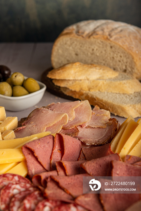 Picada, plato típico de embutidos, quesos y aceitunas, aperitivo argentino y español, sobre una tabla de madera.