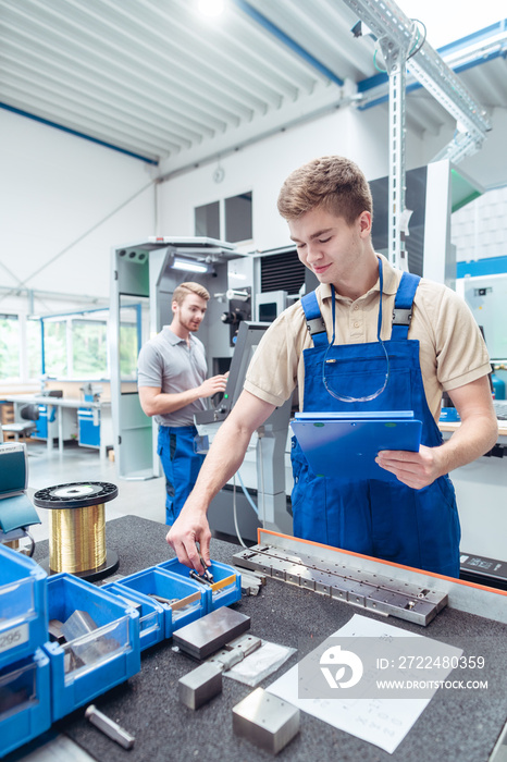 Worker looking for small parts to continue manufacturing stuff in factory