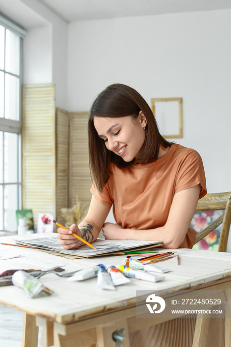 Young female artist drawing in workshop