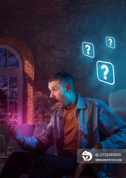 Man using gadget and receive neon notifications at home at night. Sitting on armchair, serfing in internet and looking for information. Social media abusing, chatting and browsing, gadget addiction.