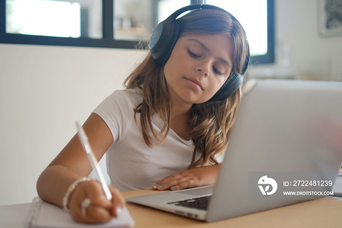 young girl on a laptop computer doing her lessons at home