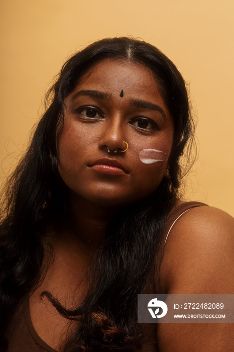 South Asian female solo lifestyle studio portrait skin care shot