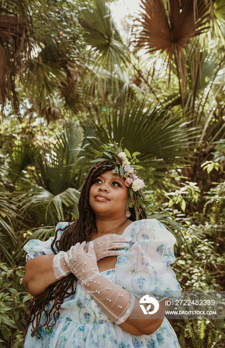 plus size woman crosses hands on chest looking at trees