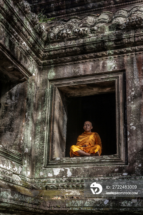 Young Buddhist monk meditating in temple in Angkor Wat, Siem Reap, Cambodia