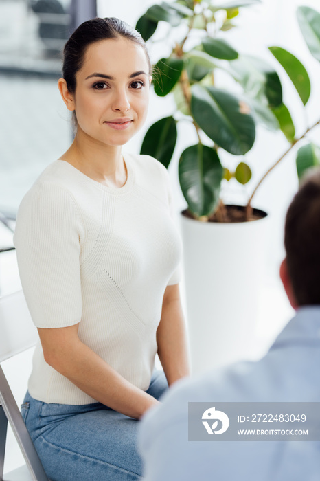 selective focus of woman sitting and looking at camera during therapy session