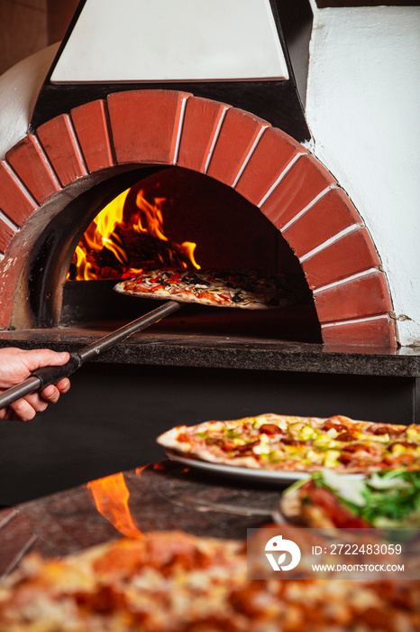 the chef takes pizza. Italian pizza is cooked in a wood-fired oven