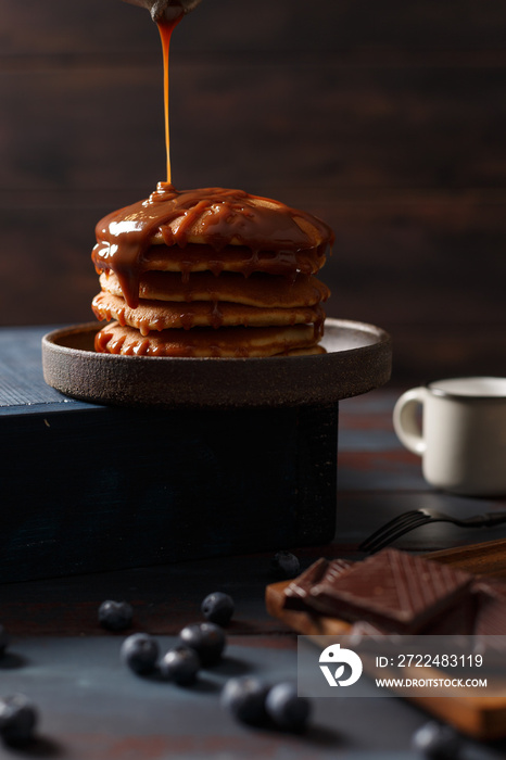 Crêpes sur une assiette et le chocolat chaud à coté. Le chocolat coule sur les crêpes.