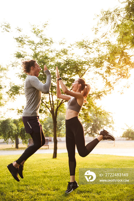 Excited fitness sport loving couple gives a high five to each other.