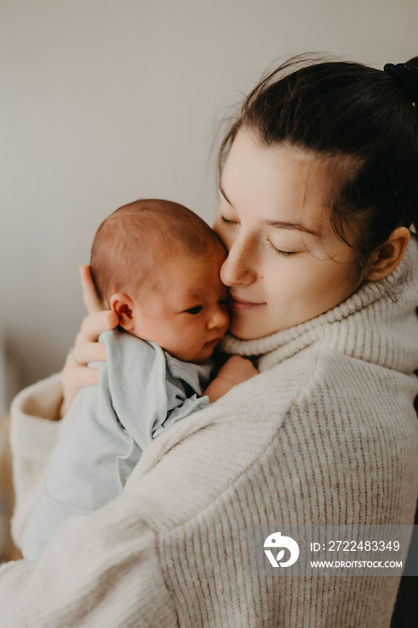 Beautiful woman holds a newborn baby in her arms