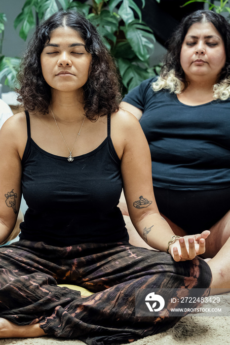 Friends meditating together at home