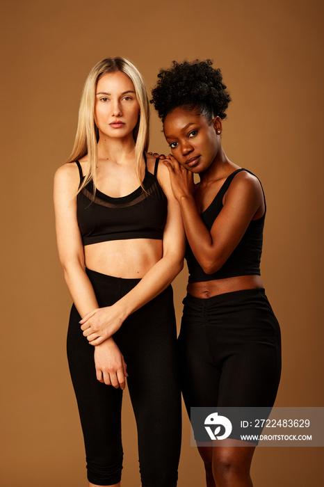 Beauty photography of two multiracial girls with natural skin posing in studio.