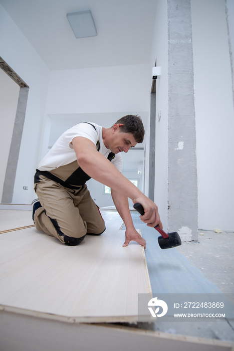 Professional Worker Installing New Laminated Wooden Floor