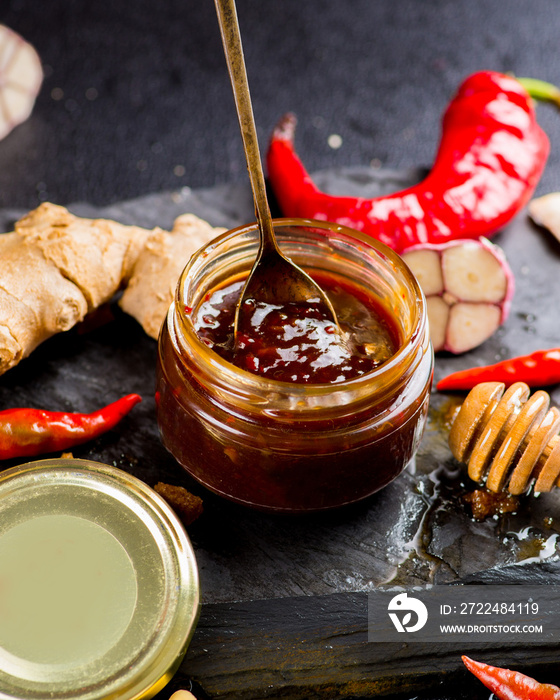 teriyaki sauce in a jar and ingredients from it on a black background