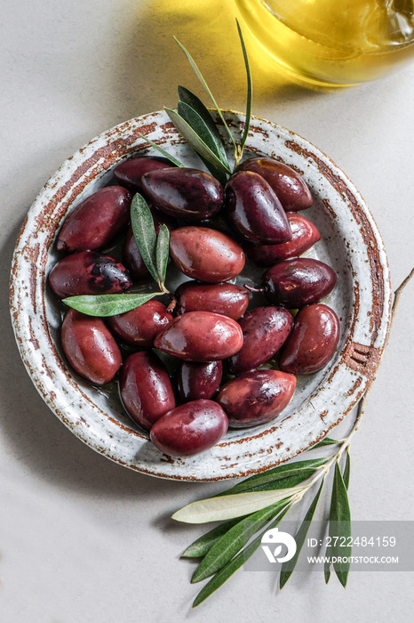 Kalamata olive, Aceitunas Kalamon and grissini breadsticks, olive oil. mediterranean snacks on the white modern style, top view