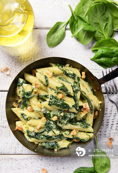 Penne pasta with spinach, gorgonzola cheese and walnuts