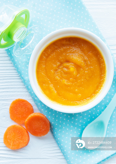 Baby carrot mashed with spoon in bowl