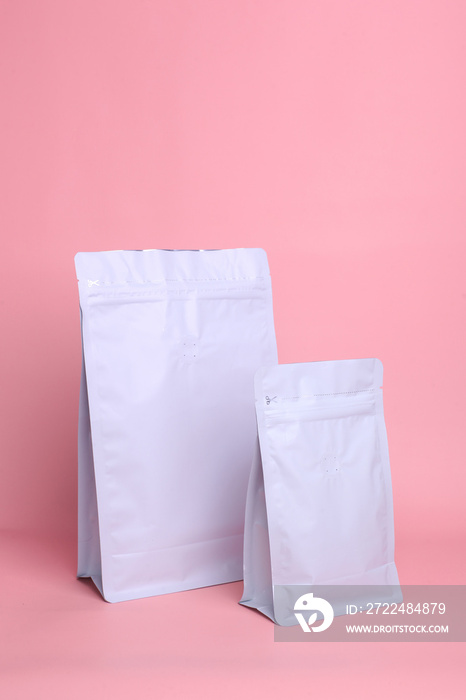 Standing pouch bags with zip lock and valve on pink background, mock up for coffee packaging. Top view. Use for template your design, presentation, promo, ad.