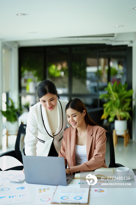 Portrait of two female employees using computers during work.