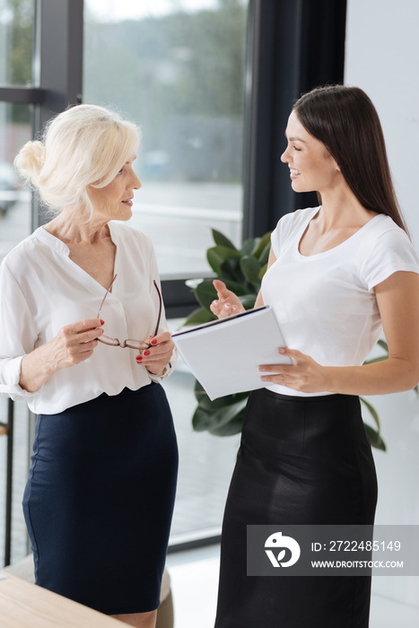 Smart delighted colleagues talking to each other