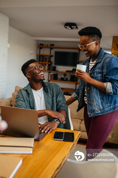 Two black workers in the home office, using technology