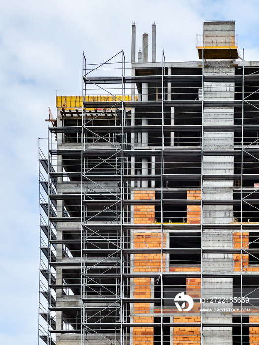 Apartment building construction site with scaffolding surrounding the built structure