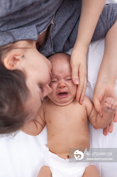 Mom soothes a crying newborn, top view