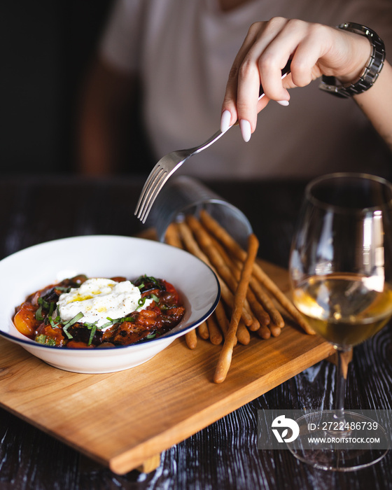 Appetizing dish on a dark wooden table. Vegetable stew with egg.