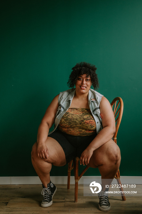 portrait of a plus size afro indigenous person sitting on chair