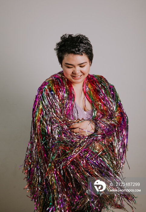 portrait of a plus size woman wrapped in tinsel eyes closed