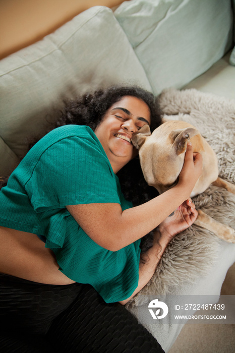 Curvy Indian girl with Cerebral Palsy cuddling her dog in the living room