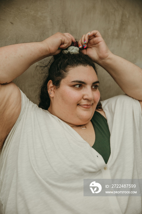 plus size woman adjusts ponytail