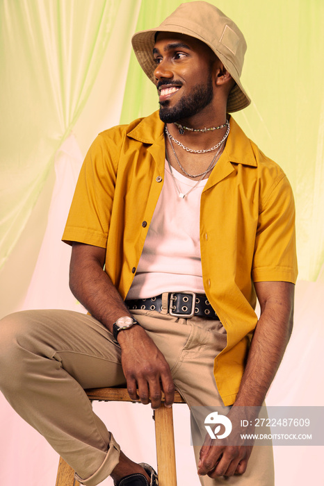 Malaysian Indian men laughing and posing together against a cloth backdrop in a studio setting, wearing fashionable clothing