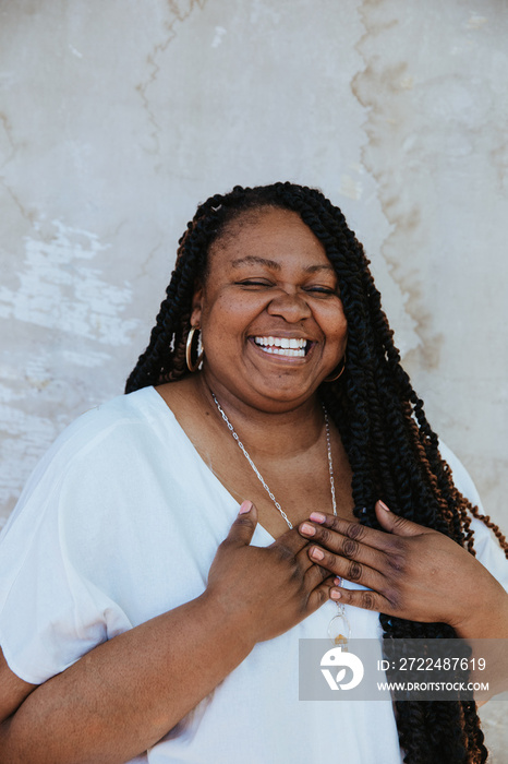 portrait of a plus size African American woman smiling hands on heart eyes closed