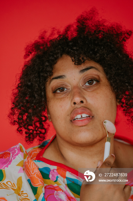 closeup of a plus size black person using a face roller