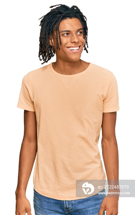 Young african american man wearing casual clothes looking away to side with smile on face, natural expression. laughing confident.