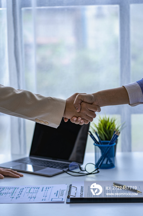 A young woman shakes hands with her supervisor while in front of the directors during company meetings or interviews for collaboration ideas, careers and job titles.