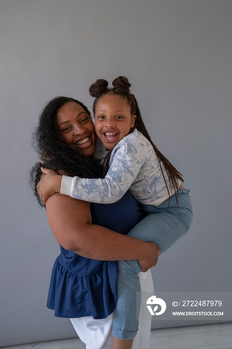 Smiling mother holding daughter (6-7)