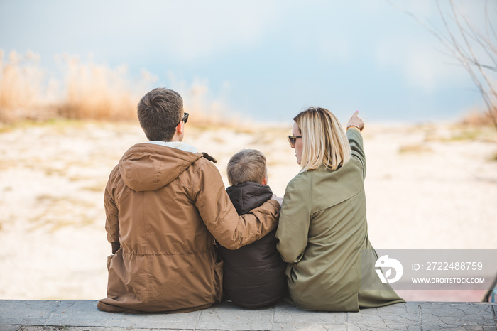 young beautiful family sitting at beach with view lake