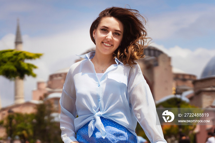 European girl in a blue skirt on the background of a mosque. photo session of a girl on the background of hagia sophia in istanbul. photo of a tourist in istanbul against the backdrop of attractions