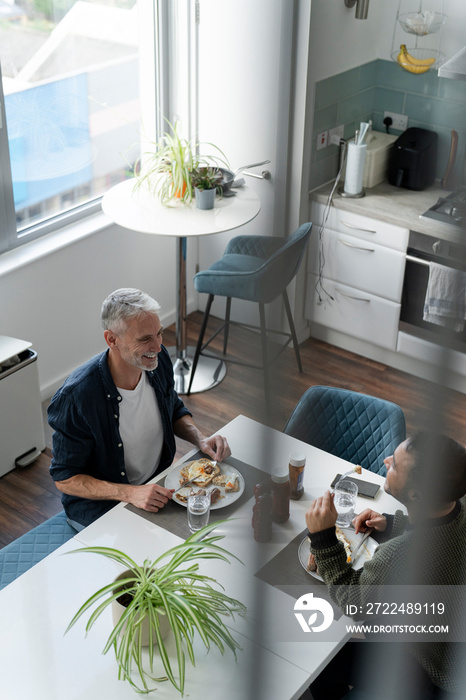 Male couple eating breakfast at home