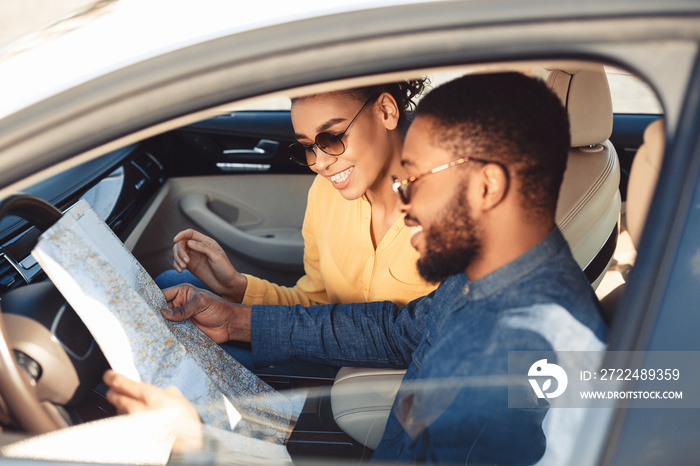 Spouses Looking At Map Sitting In Car Traveling On Vacation