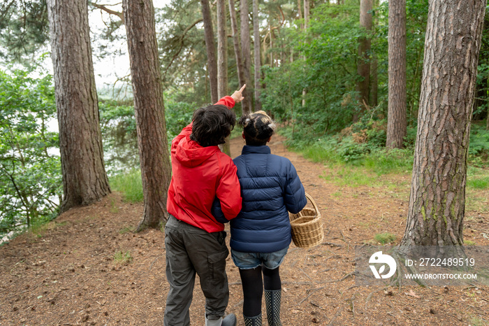 Mother and son walking in forest with basket