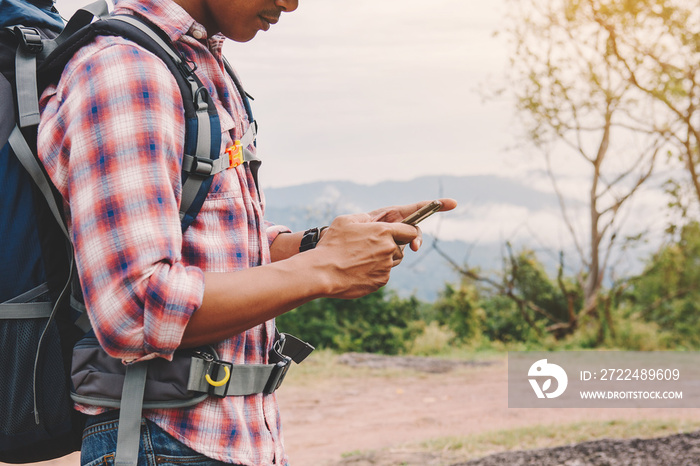 Hiking man with backpack using phone in mountains, Travel lifestyle success concept adventure